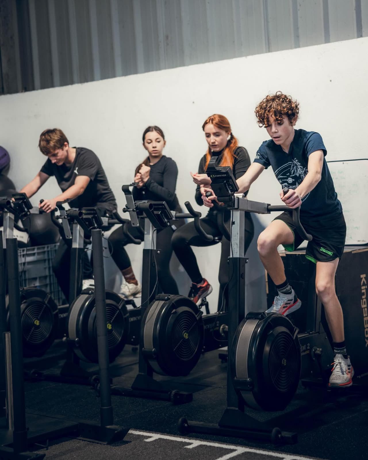 Athletes Kurnos sur rameurs et assault bikes, entrainement collectif